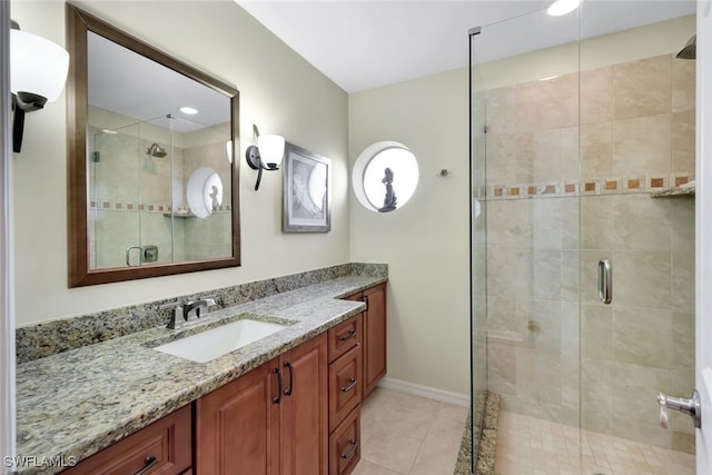 bathroom featuring tile patterned flooring, a shower with shower door, and vanity