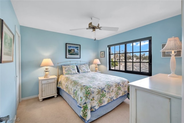 bedroom with light carpet, a ceiling fan, and baseboards