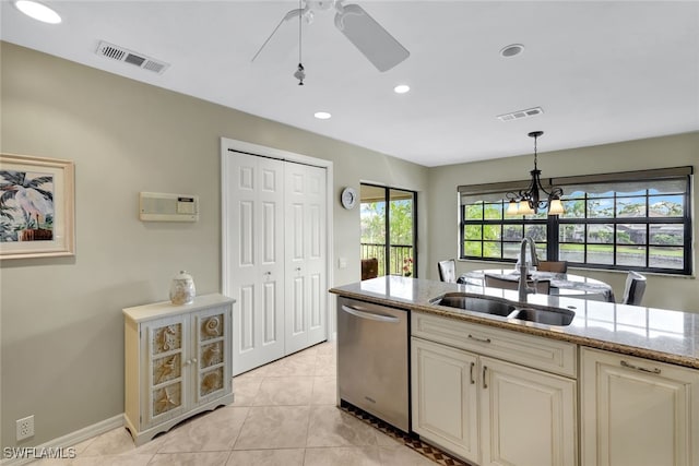 kitchen with pendant lighting, sink, light tile patterned flooring, light stone counters, and stainless steel dishwasher