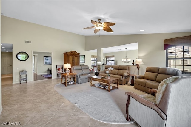 living room featuring ceiling fan with notable chandelier, light tile patterned floors, and lofted ceiling