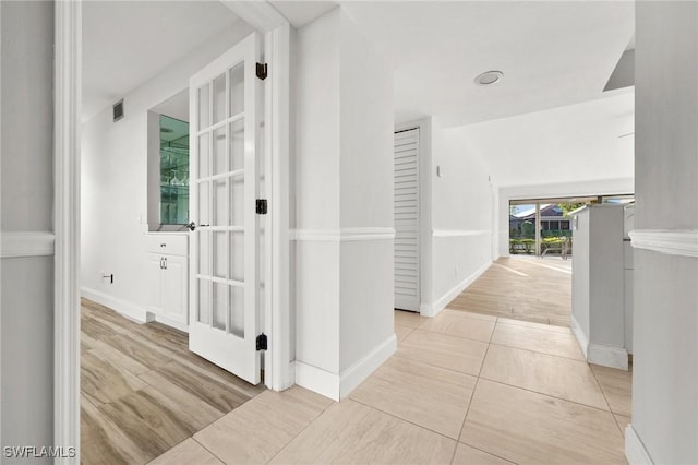 hallway featuring light tile patterned floors and vaulted ceiling