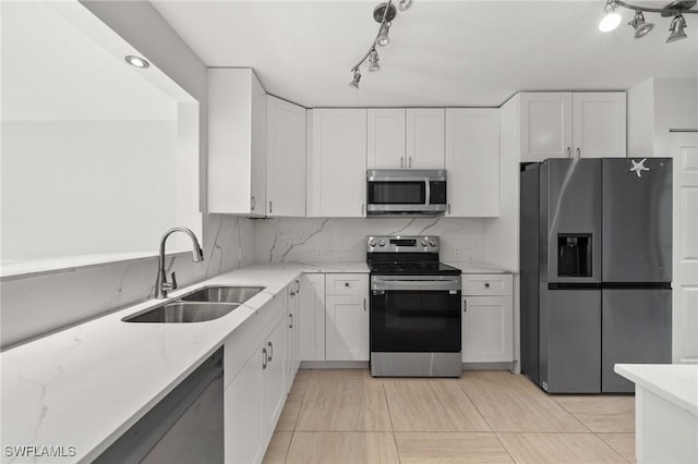 kitchen with decorative backsplash, white cabinetry, sink, and appliances with stainless steel finishes