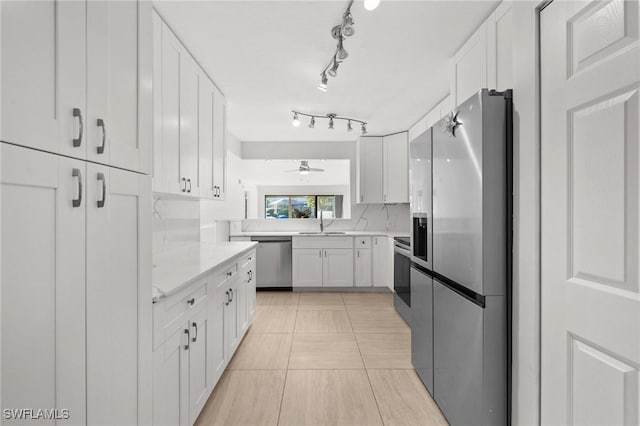 kitchen featuring sink, stainless steel appliances, white cabinets, backsplash, and light tile patterned flooring