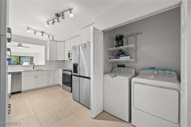 laundry room with washer and clothes dryer, ceiling fan, light tile patterned floors, and sink