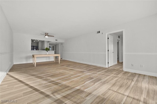 unfurnished living room with ceiling fan and wood-type flooring