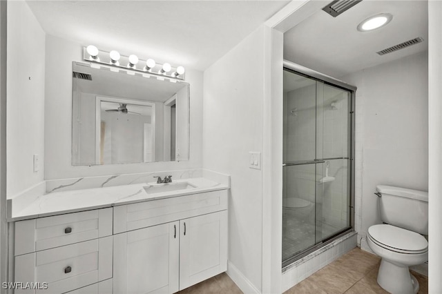 bathroom with tile patterned floors, vanity, a shower with door, ceiling fan, and toilet