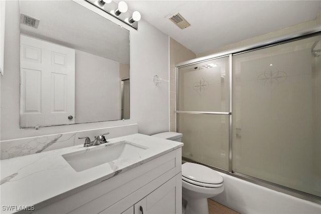 full bathroom featuring shower / bath combination with glass door, vanity, and toilet