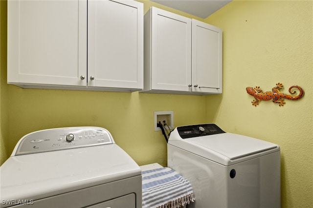 laundry area featuring separate washer and dryer and cabinet space