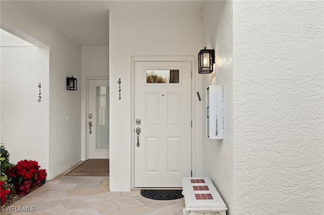 entrance to property featuring stucco siding