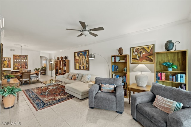 living room featuring arched walkways, light tile patterned flooring, crown molding, and ceiling fan