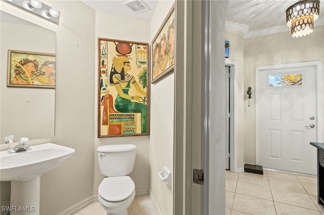 bathroom with visible vents, toilet, ornamental molding, tile patterned floors, and a sink