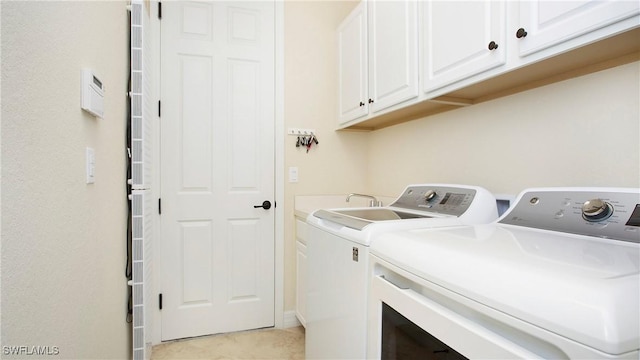 clothes washing area featuring separate washer and dryer, light tile patterned flooring, and cabinets