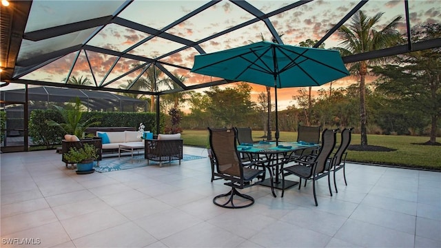 patio terrace at dusk featuring a lanai and an outdoor hangout area