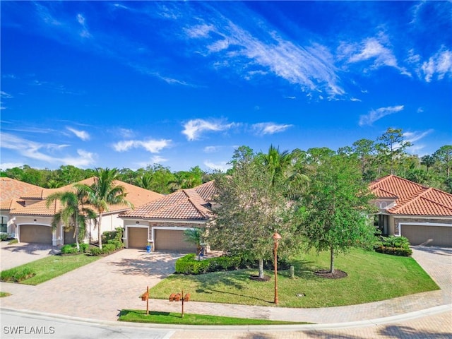 mediterranean / spanish house with a front yard and a garage