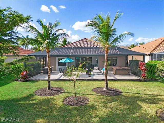 rear view of property with a yard, a hot tub, and a patio area