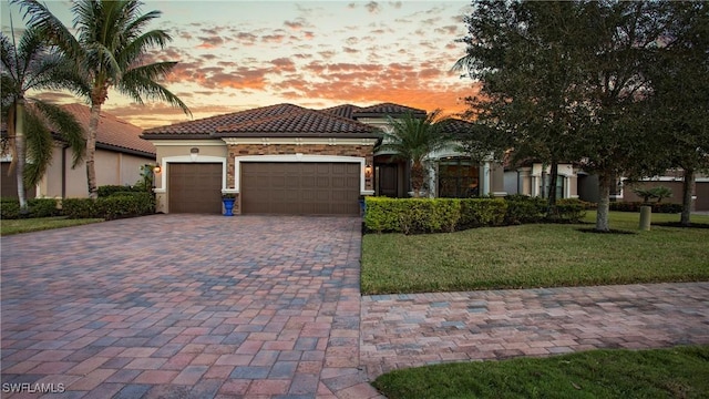 mediterranean / spanish-style house with a lawn and a garage