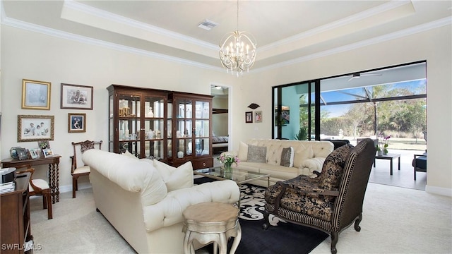 living room with a raised ceiling, a chandelier, crown molding, and light colored carpet