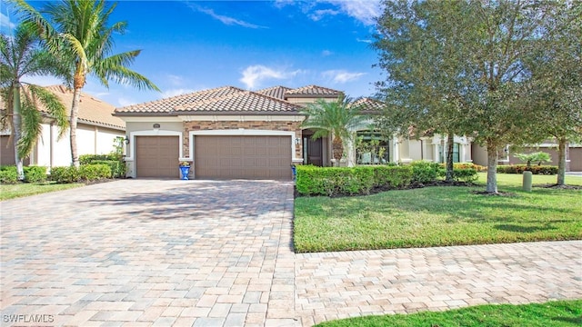 mediterranean / spanish house featuring a garage and a front yard