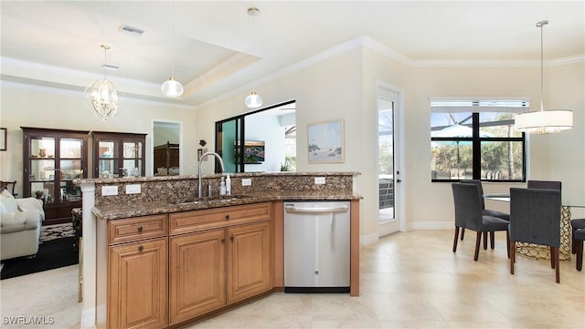 kitchen featuring pendant lighting, dishwasher, sink, dark stone countertops, and a chandelier