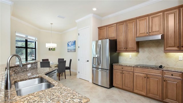 kitchen with sink, light stone countertops, ornamental molding, appliances with stainless steel finishes, and decorative light fixtures