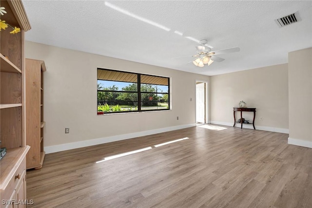 unfurnished living room featuring ceiling fan, a textured ceiling, and light hardwood / wood-style flooring