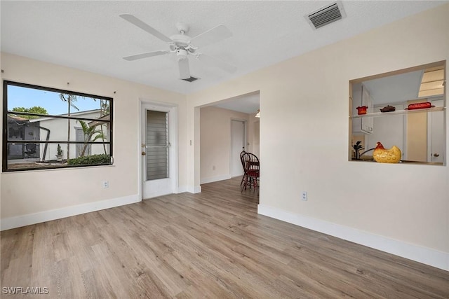 empty room with ceiling fan and light hardwood / wood-style flooring