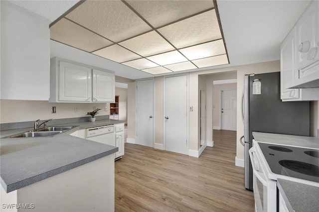 kitchen with a drop ceiling, white appliances, sink, light hardwood / wood-style flooring, and white cabinets