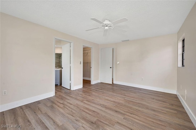 spare room featuring ceiling fan, light hardwood / wood-style floors, and a textured ceiling