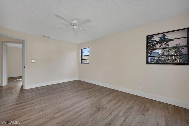 unfurnished room with hardwood / wood-style flooring, ceiling fan, and a textured ceiling