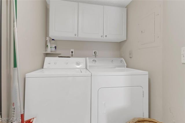 clothes washing area featuring washer and clothes dryer and cabinets