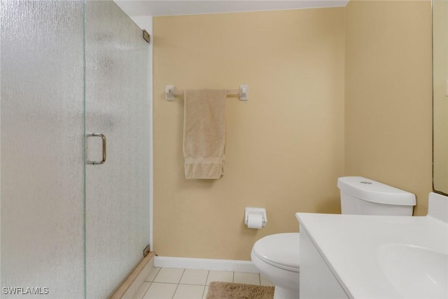 bathroom featuring toilet, vanity, tile patterned floors, and an enclosed shower