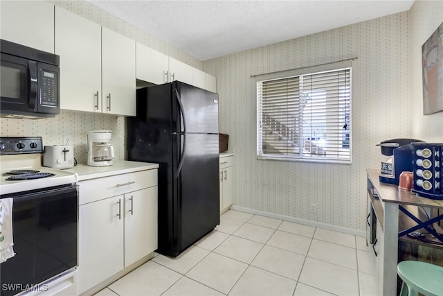 kitchen featuring light tile patterned flooring, white cabinets, black appliances, and a textured ceiling