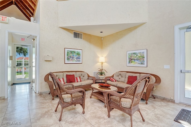 tiled living room with beamed ceiling and high vaulted ceiling