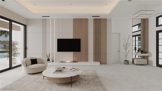 living room with plenty of natural light, a raised ceiling, and light tile patterned floors