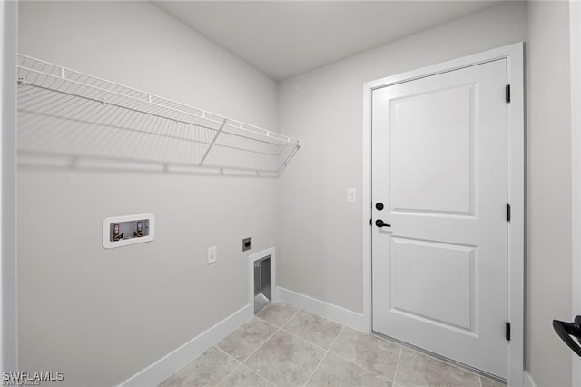 clothes washing area featuring hookup for an electric dryer, washer hookup, and light tile patterned floors