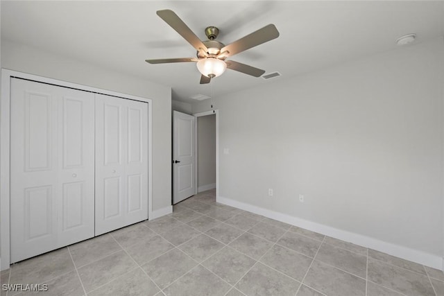 unfurnished bedroom featuring light tile patterned floors, a closet, and ceiling fan