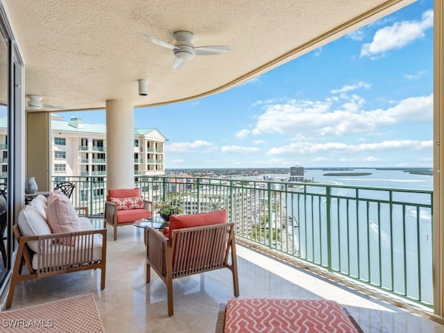 balcony featuring ceiling fan and a water view