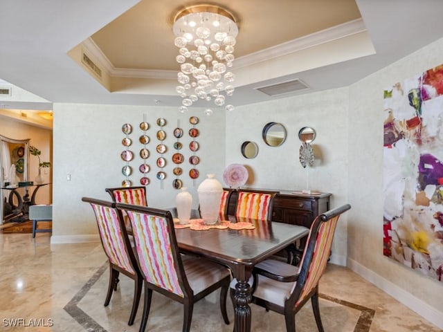 dining space featuring an inviting chandelier, ornamental molding, and a tray ceiling