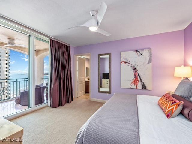 bedroom with ceiling fan, access to exterior, light colored carpet, and a water view