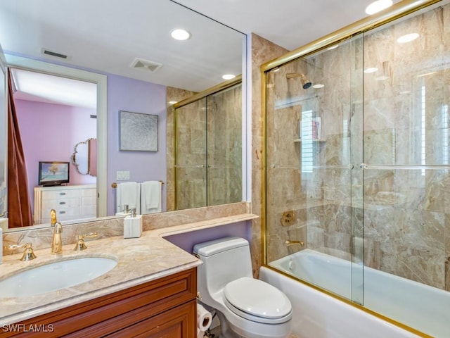 full bathroom with vanity, toilet, and shower / bath combination with glass door