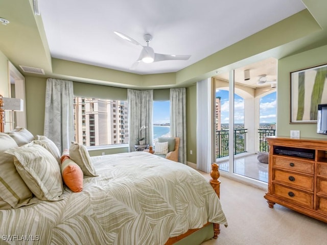 bedroom featuring ceiling fan, light colored carpet, access to outside, and multiple windows