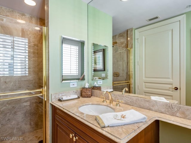 bathroom with plenty of natural light, vanity, and a shower with door