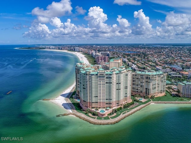 birds eye view of property with a water view and a beach view