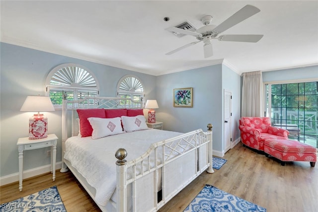 bedroom with hardwood / wood-style flooring, ceiling fan, and ornamental molding