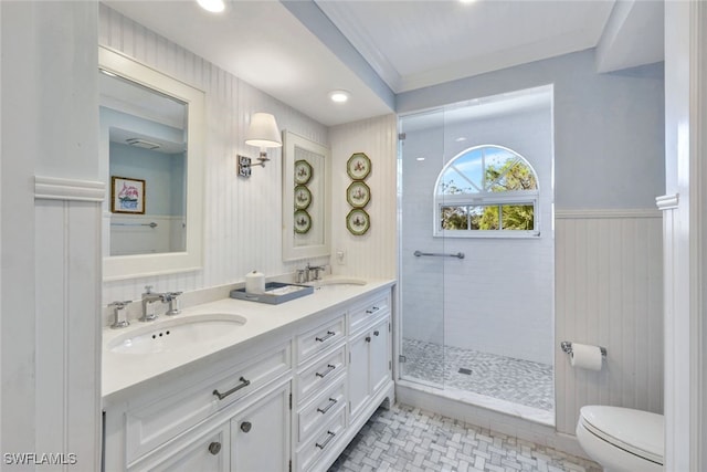 bathroom featuring vanity, tile patterned flooring, toilet, ornamental molding, and a tile shower