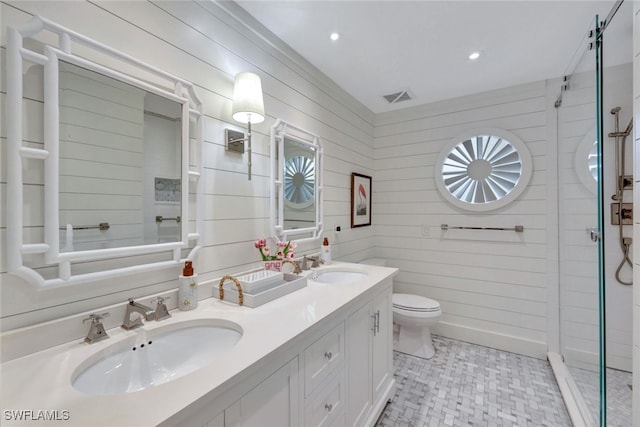 bathroom featuring a shower, wood walls, vanity, and toilet