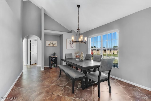 dining space featuring high vaulted ceiling and a chandelier