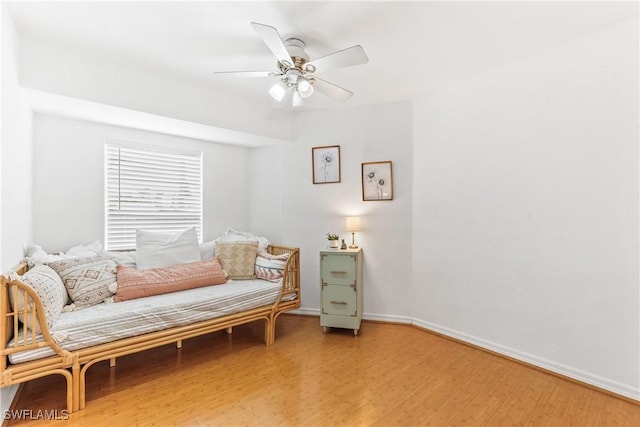 sitting room with ceiling fan and hardwood / wood-style flooring