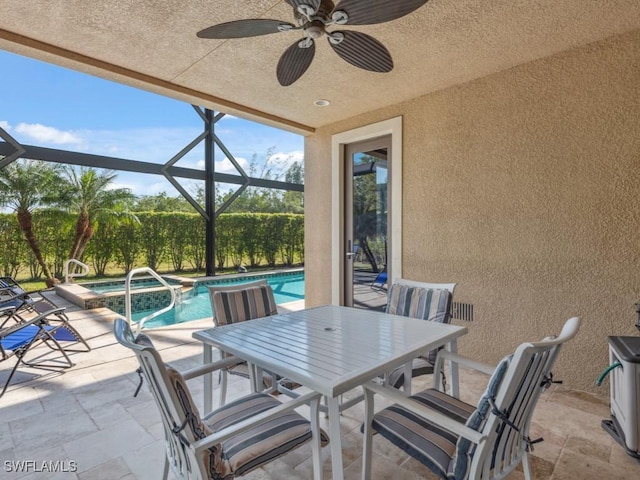 view of patio featuring ceiling fan, a swimming pool with hot tub, and glass enclosure