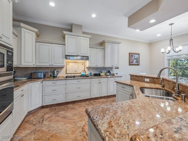 kitchen featuring decorative backsplash, crown molding, sink, an inviting chandelier, and white cabinetry